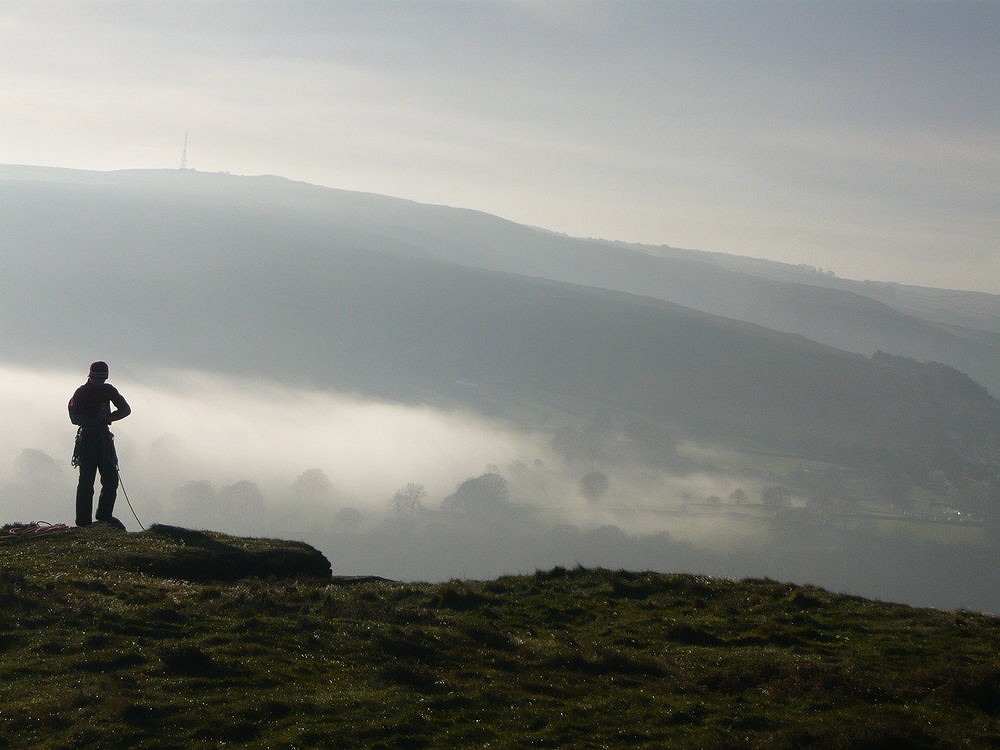 Silhouette of climber at top of Burbage Edge, Sheffield England. Misty morning  © calciumcarbonate