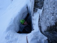 Squeezing out the tunnel, at the end of Pitch 2, West Chimney, Church Door Buttress.