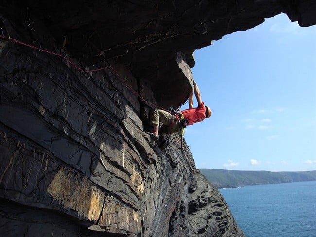 Dave Turnbull following pitch two of the Cushion Man - reclipping the gear to protect the next climber.  © Mick Fowler