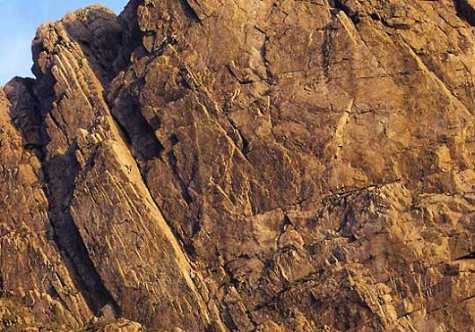 The mighty Scafell Crag on a midsummer evening. Climbers can be seen on Botterill's Slab.  © Gordon Stainforth