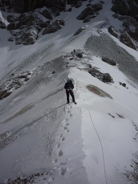 One foot in Kyrgyzstan, one foot in China:  Robert Taylor on the ridge traverse leading to the summit of Mur Samir.  Photo Copy  © Photos are copyright to the appropriate photographer (Adam Russ