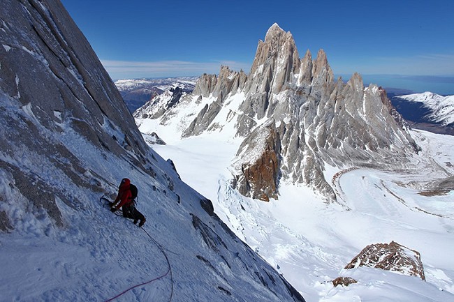 Will Sim making a calf burning traverse with the Fitz Roy massif in the distance  © Jon Griffith / Alpine Exposures