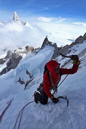 Will Sim just below the summit with the clouds already covering part of Cerro Torre  © Jon Griffith / Alpine Exposures