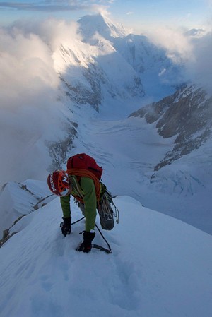Will Sim on the Cowboy arete, sun setting in the background.  © Jon Griffith / Alpine Exposures