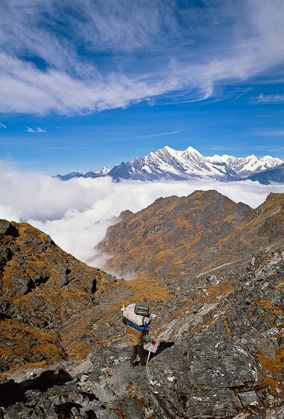 A heavily loaded Sherpa porter returning from Mera Peak, starts the descent from the 4610m Zatrwa La pass, Nepal.  © Stuart Scott