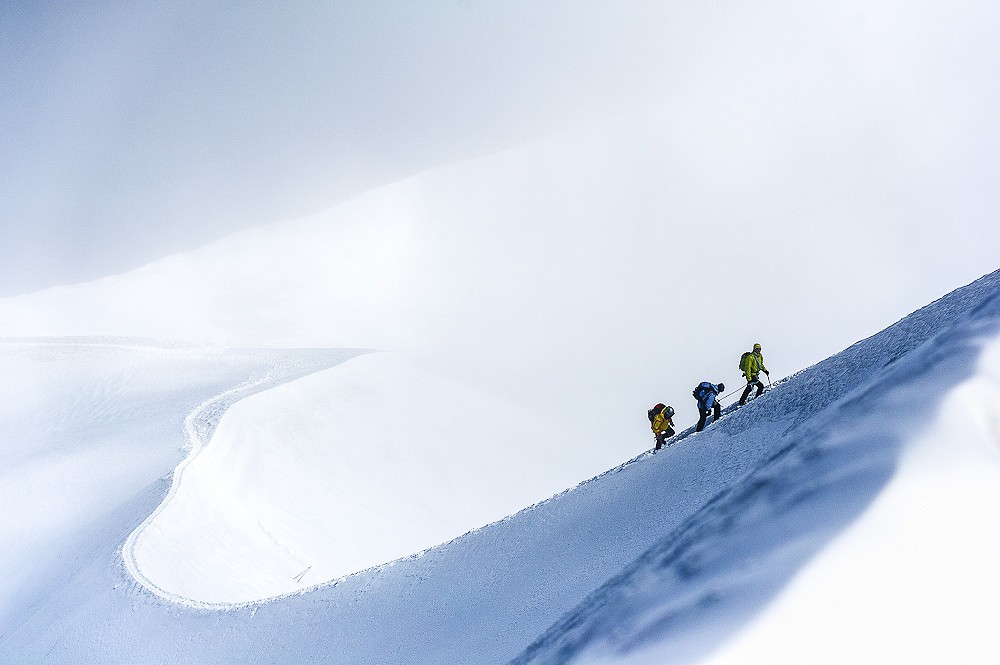 An IVBV mountain guide leads his climbers along snowy arete of Aiguille du Midi.  © Kamil Tamiola
