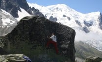 Climbing the Slab boulder with the Dome du Gouter in the background.
