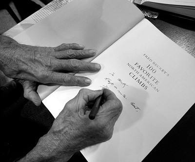 Fred Beckey signing a copy of his magnum opus, Fred Beckey's 100 Favorite North American Climbs.  © Mick Ryan