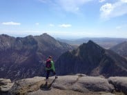Dayni the explorer on the summit of Caisteal Abhail looking towards Cir Mhor, Goatfell and Holy Isle.
