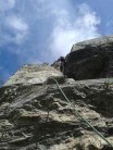 A shot looking up of climber on jugs, mostly sunny but windy day