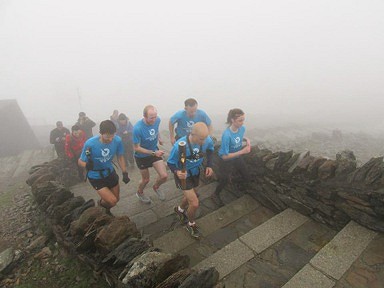 Eryri Harriers carrying the baton to the summit of Snowdon