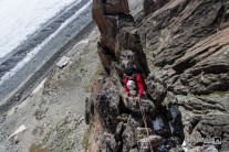 Climber on the narrow ridge of Gateau de Riz, route in Aiguille du Refuge above Argentiere hut in Mont-Blanc range