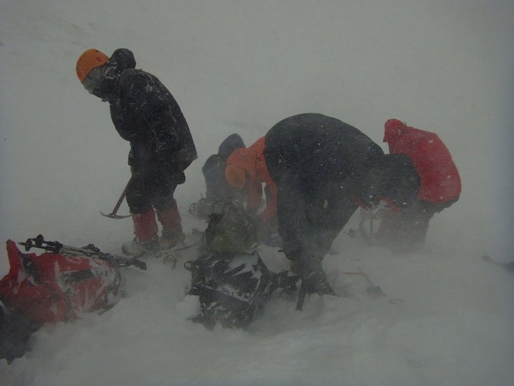 Putting crampons on in a blizzard, gloves a must!  © Samantha Leary