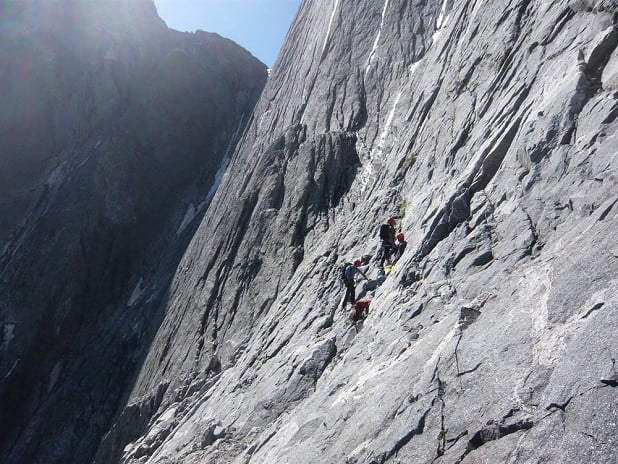 Teams waiting on the Vire Mediante below the crux 6a pitch.  © Peter Metcalfe