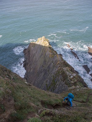 Scrambling up the mud/choss en route to Long Rock at Baggy Point  © Rob Greenwood - UKC