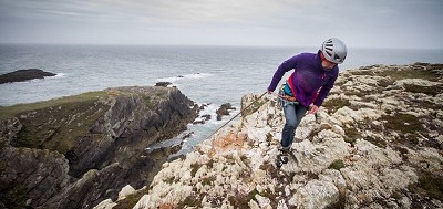 Libby Peters topping out on a windy day at Rhoscolyn  © Rab