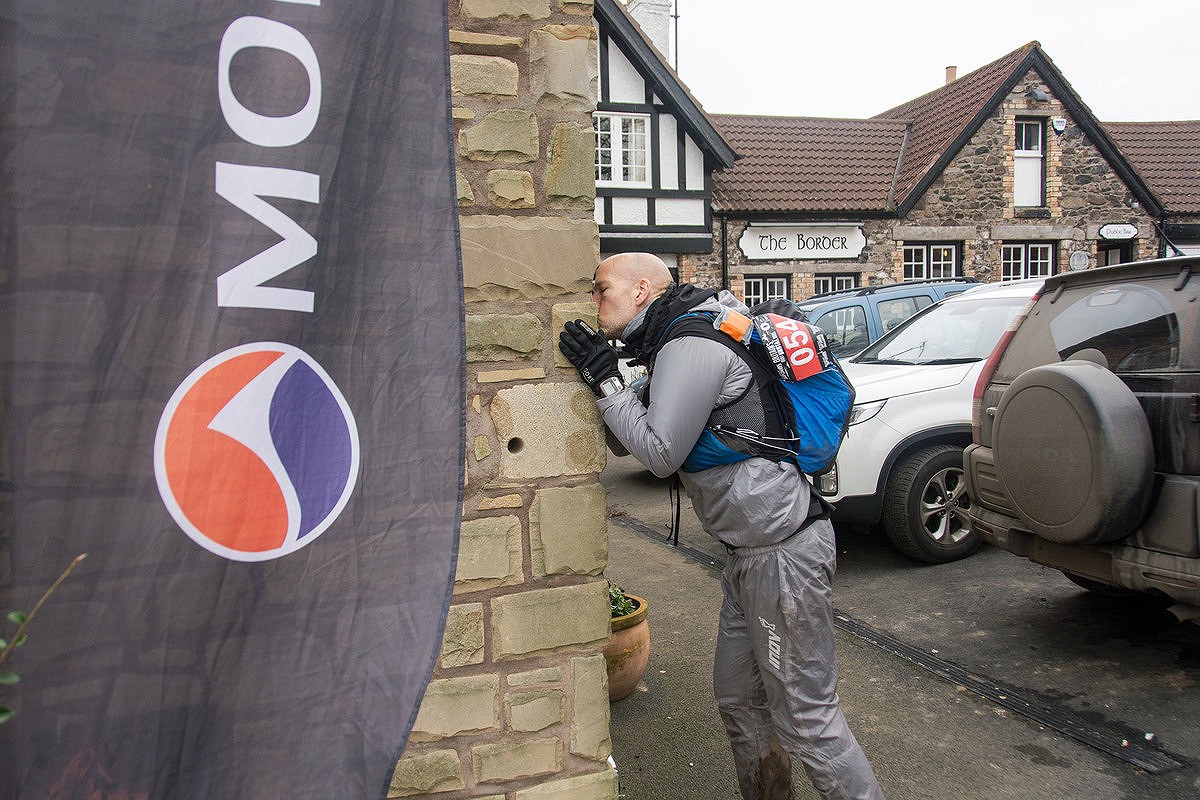 Tom Hollins kisses the end wall of the Pennine Way  © Mick Kenyon/Montane Spine Race