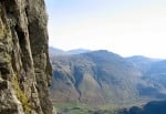 Climber on Inertia (HVS 5a), Gimmer Crag, Lake District. The big corner is The Crack (VS 4c)