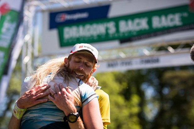 Marcus Scotney embraced by wife Jen after winning the 2017 Berghaus Dragon's Back Race  © Guillam Casanova