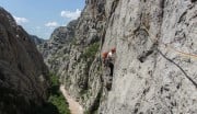 Climbing the famous traverse on route Senza Pieta above the canyon of Paklenica, Croatia