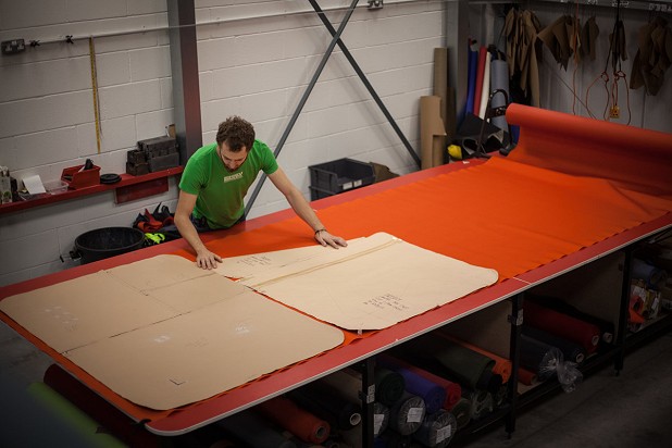 Alpkit Team Member Nick Priestley cutting the fabric for a bouldering mat  © Rob Greenwood - UKC