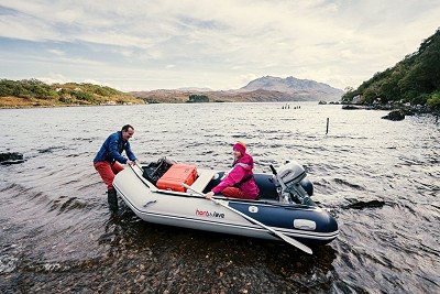 Dave and Natalie preparing for a day of sport climbing at Loch Maree. First things first: blow up the boat!  © Dark Sky Media
