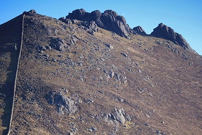 The Mourne Wall rising steeply to the summit of Slieve Bearnagh, which is lined with a series of rocky tors  © Adrian Hendroff