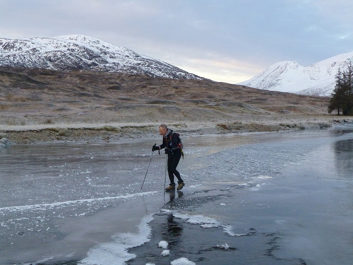 Tom Phillips crosses the frozen surface of the Abhainn Rath on a winter round  © John Carr