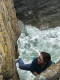Katie soloing Fishermans Friend above a wild sea