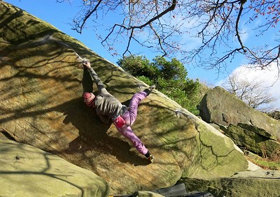 Florence Pinet uses a heel-hook to solve the Green Traverse V6 at Stanage.   © Neil Gresham Col.
