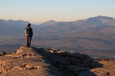Aled Williams on top of Foel Penolau with Snowdon in the background  © Myrddyn Phillips