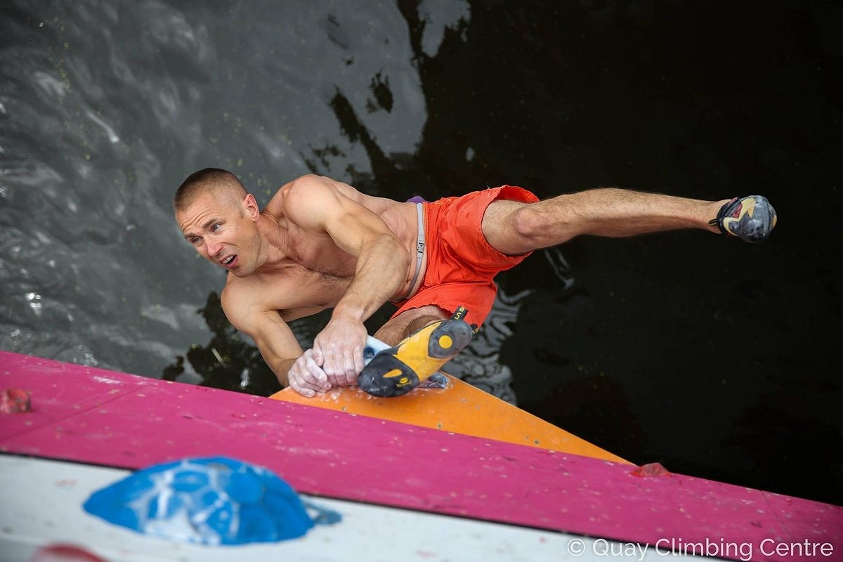 Neil Gresham demonstrating toe hooks at a deep water soloing competition  © Neil Gresham Collection