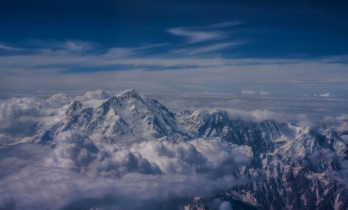 The Diamir Face of Nanga Parbat, with the Mazeno Ridge emerging from the clouds on the right.  © Rick Allen