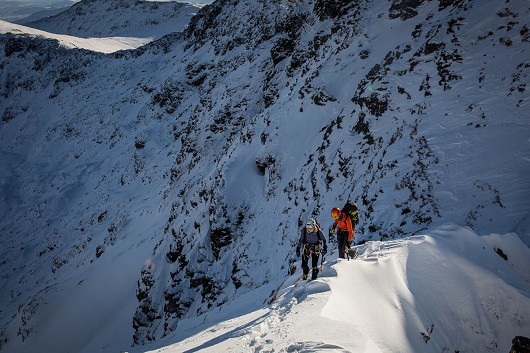 A narrow window of time to complete the infamous Aonach Eagach ridge as climbers chase the shadows.  © Jessie Leong