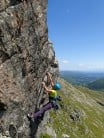 Climber on Crow's Nest Direct, Gimmer Crag on a sunny summer day