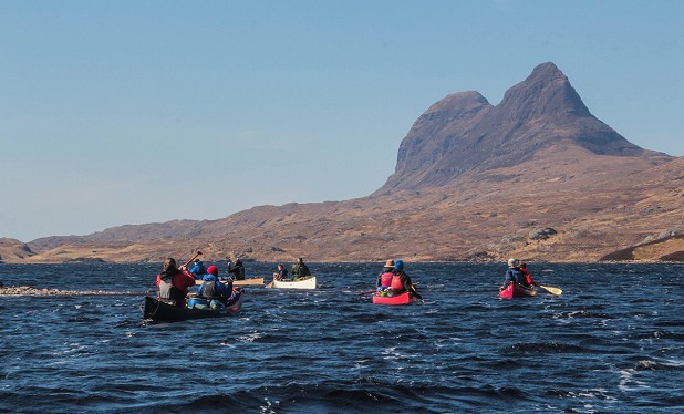 Paddling choppy water beneath the imposing form of Suilven  © Mal Grey