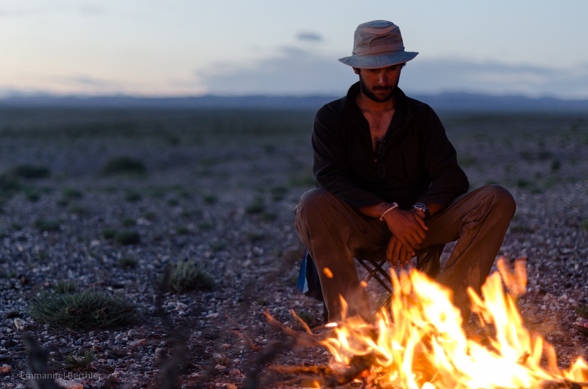 Faraz reflecting over a campfire in the Gobi desert.  © Emmanuel Berthier