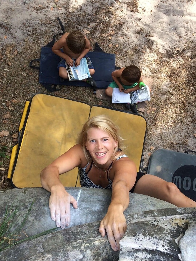Rachel Briggs bouldering while her kids study the guidebook.  © Rachel Briggs