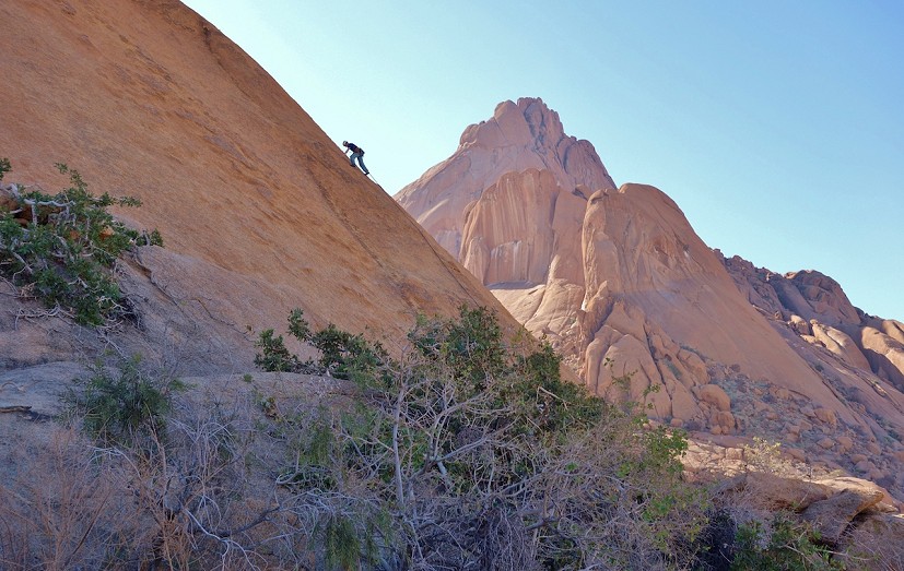 Shauna Clarke climbing on the Sugar Loaf with the Spitzkoppe behind.  © Robert Durran