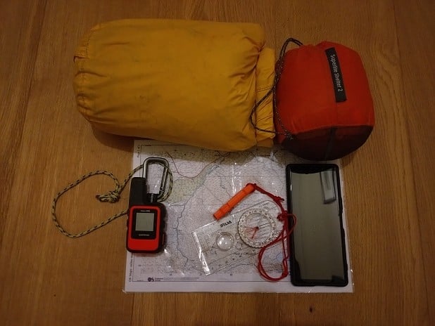 Emergency gear can be light. Blizzard bag (out of its shrink wrap), bothy shelter, phone, compass, whistle, paper map, tracker  © Roger Webb