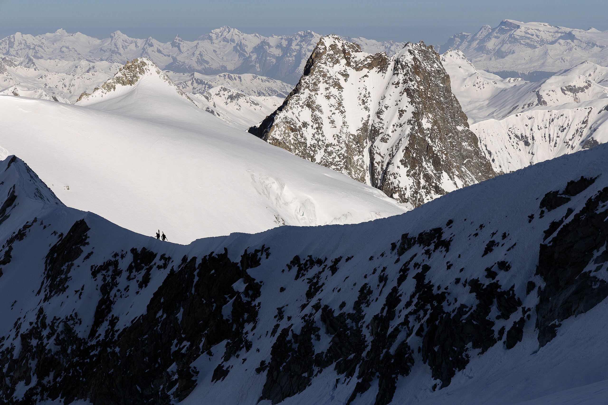 Skiers traversing the Arête De Moming in Valais, Switzerland  © Ant roberts