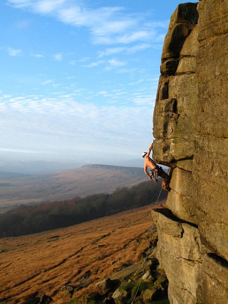 Stacking the odds: minimal clothing, tactical gear placing, trusted belayer. The author fiddling in crucial pro before the exquisite upper crux sequence on Cave Eliminate, Stanage. © Duz Walker  © Fiend
