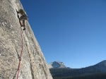 Leaving belay on third pitch of West Crack. Cathedral Peak in the background.