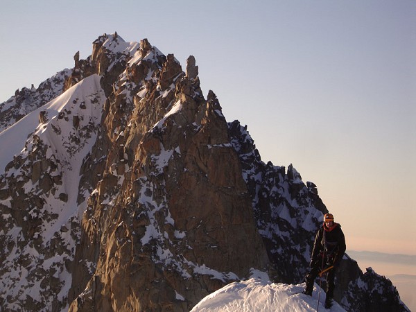Jack Geldard - wearing a belay jacket on the summit of Les Courtes in winter.  © Adrian Jebb